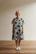 Full body view of the model wearing Essentiel Antwerp Jurk Maat 40 – Zwart-Witte Printjurk met Volantzoom en Grafisch Dessin