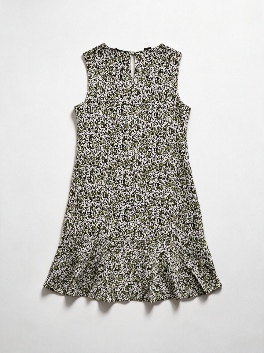 Groene mouwloze jurk met zwart-witte abstracte print en ruchezoom, achterkant liggend