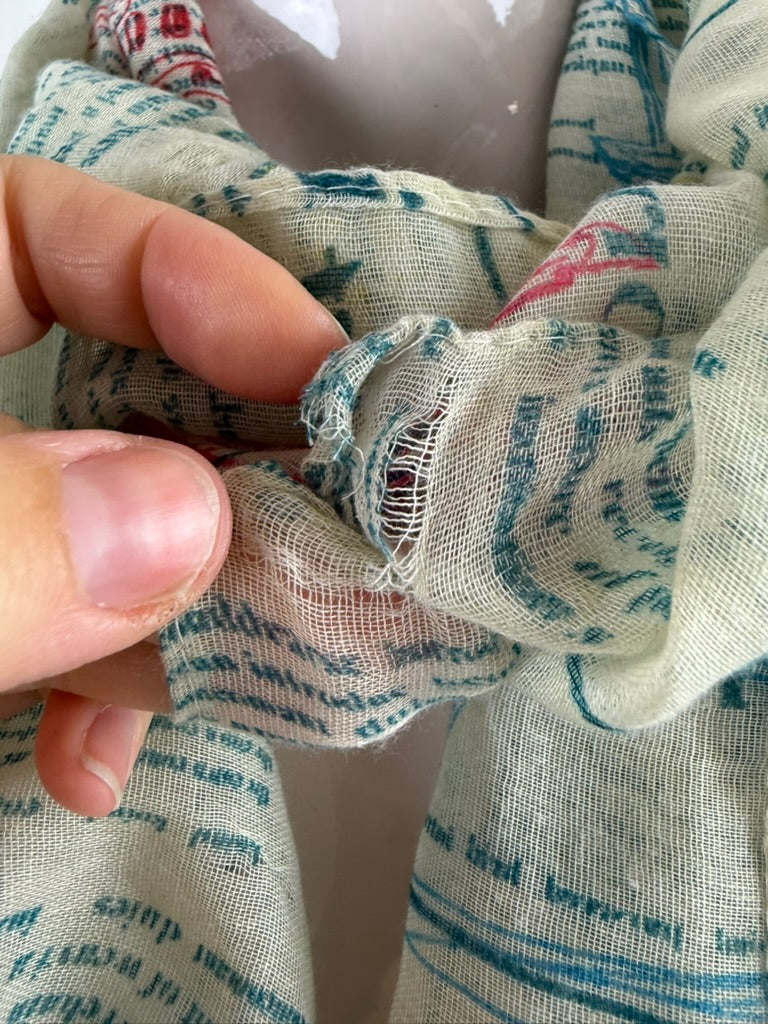 Licht mintgroene infinity sjaal met meerkleurige tekstprint, detailfoto