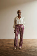 Full body view of the model wearing Corel Amsterdam Broek maat 36 Fuchsia met goudkleurig patroon