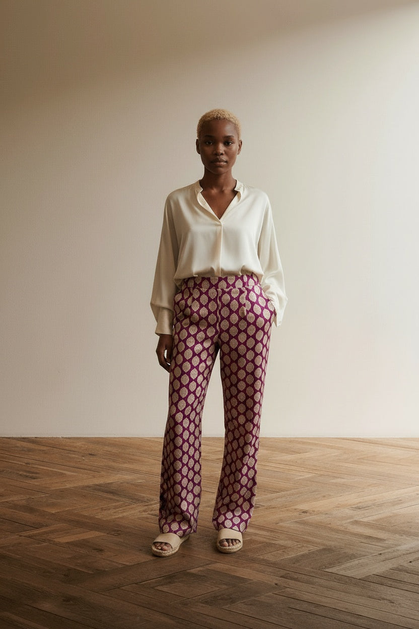 Full body view of the model wearing Corel Amsterdam Broek maat 36 Fuchsia met goudkleurig patroon