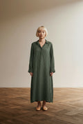 Full body view of the model wearing OSKA Crinkle Jurk Olijfgroen – Luchtige A-Lijn Jurk – Minimalistische Designerjurk