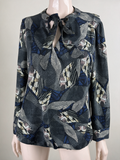Meerkleurige blouse met all-over grafische print en striksluiting bij de hals, voorkant op paspop